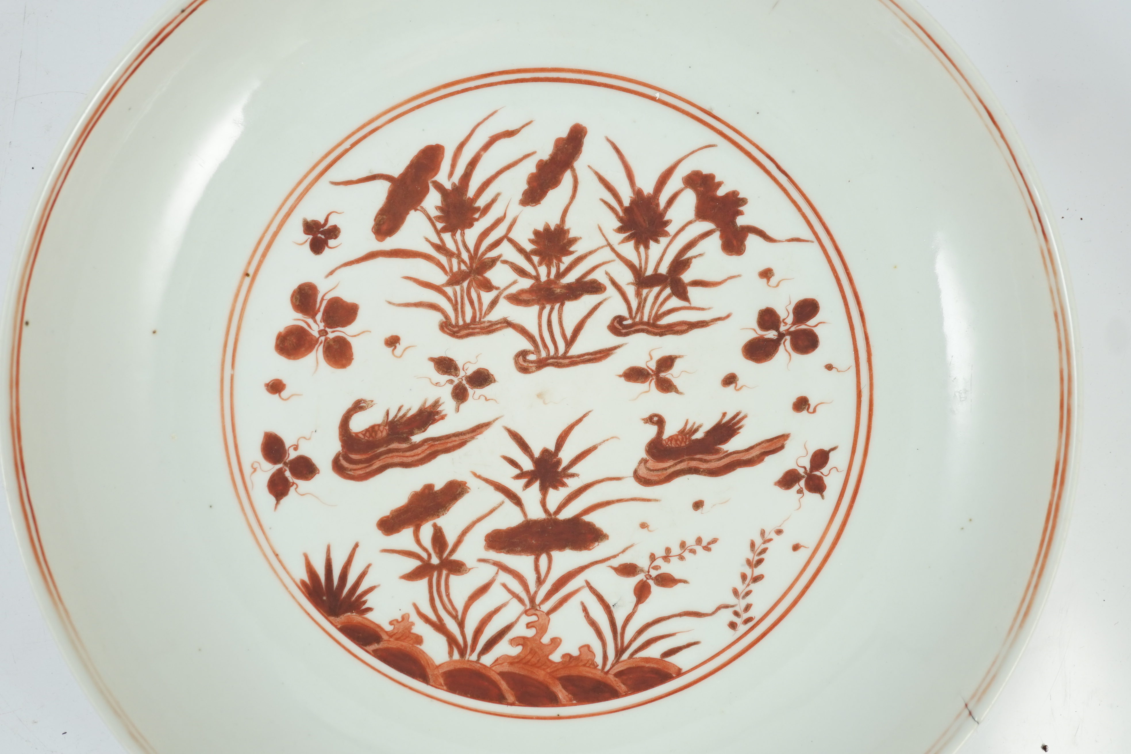 A large Chinese iron red enamelled ‘lotus pond’ dish, Wanli mark and possibly of the period